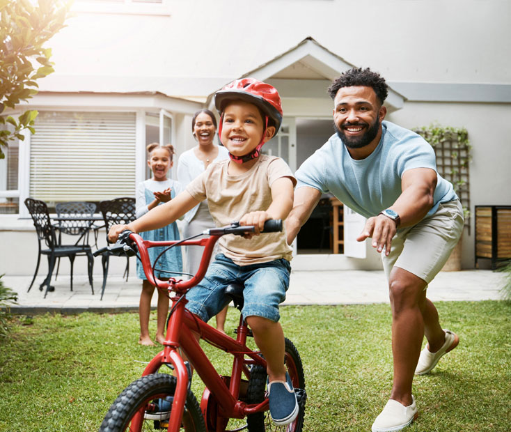 Family watching boy ride a bike
